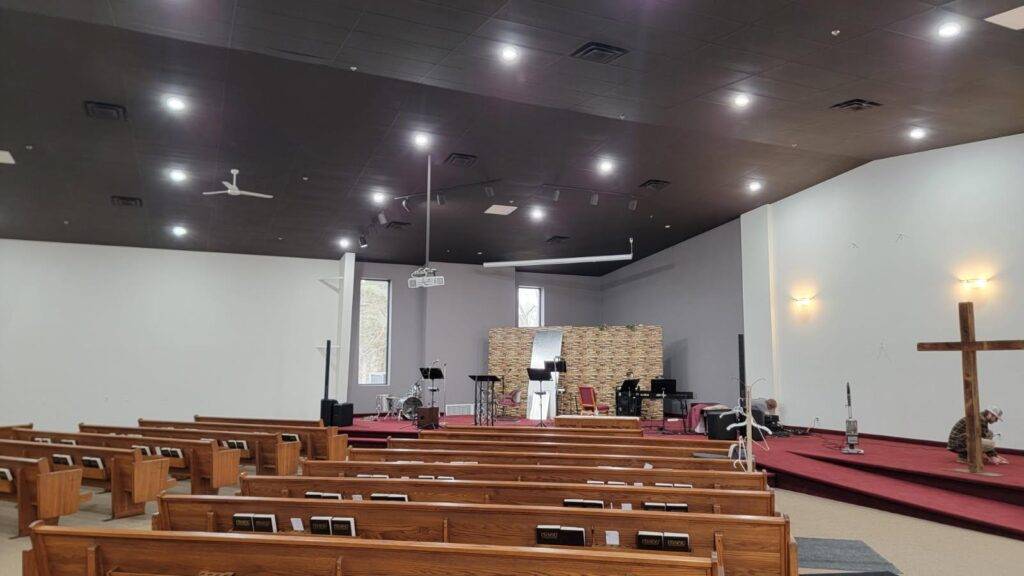 church painting Sanctuary interior painting after work — pews, stage, dark ceiling (Speese Painting)